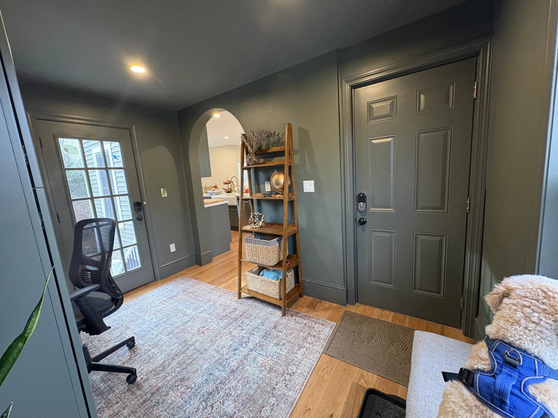 Cozy home office with shelves, a desk, and a large window letting in natural light.