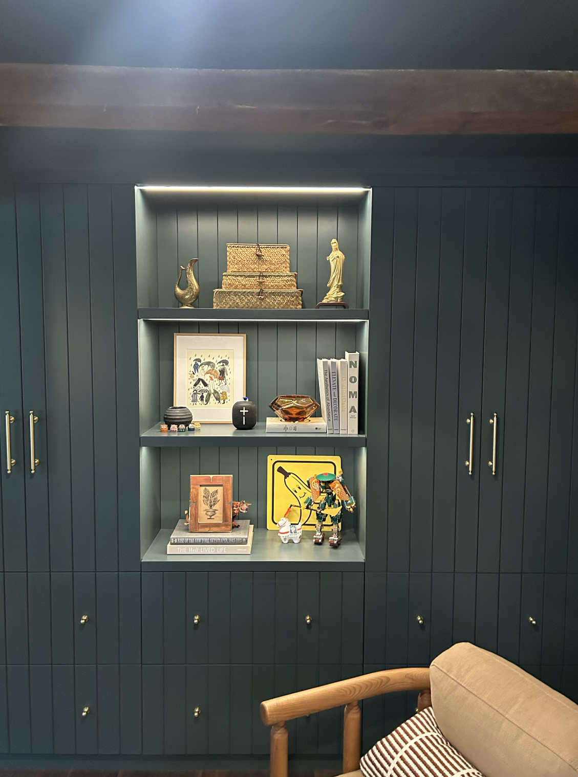 Decorative bookshelf with a ship model and various art pieces.