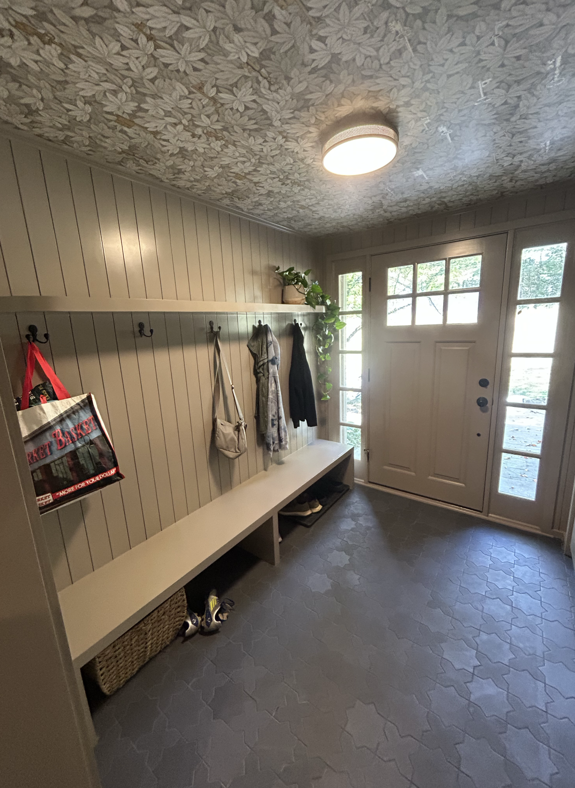 A tidy mudroom with hooks, bench, and storage space.