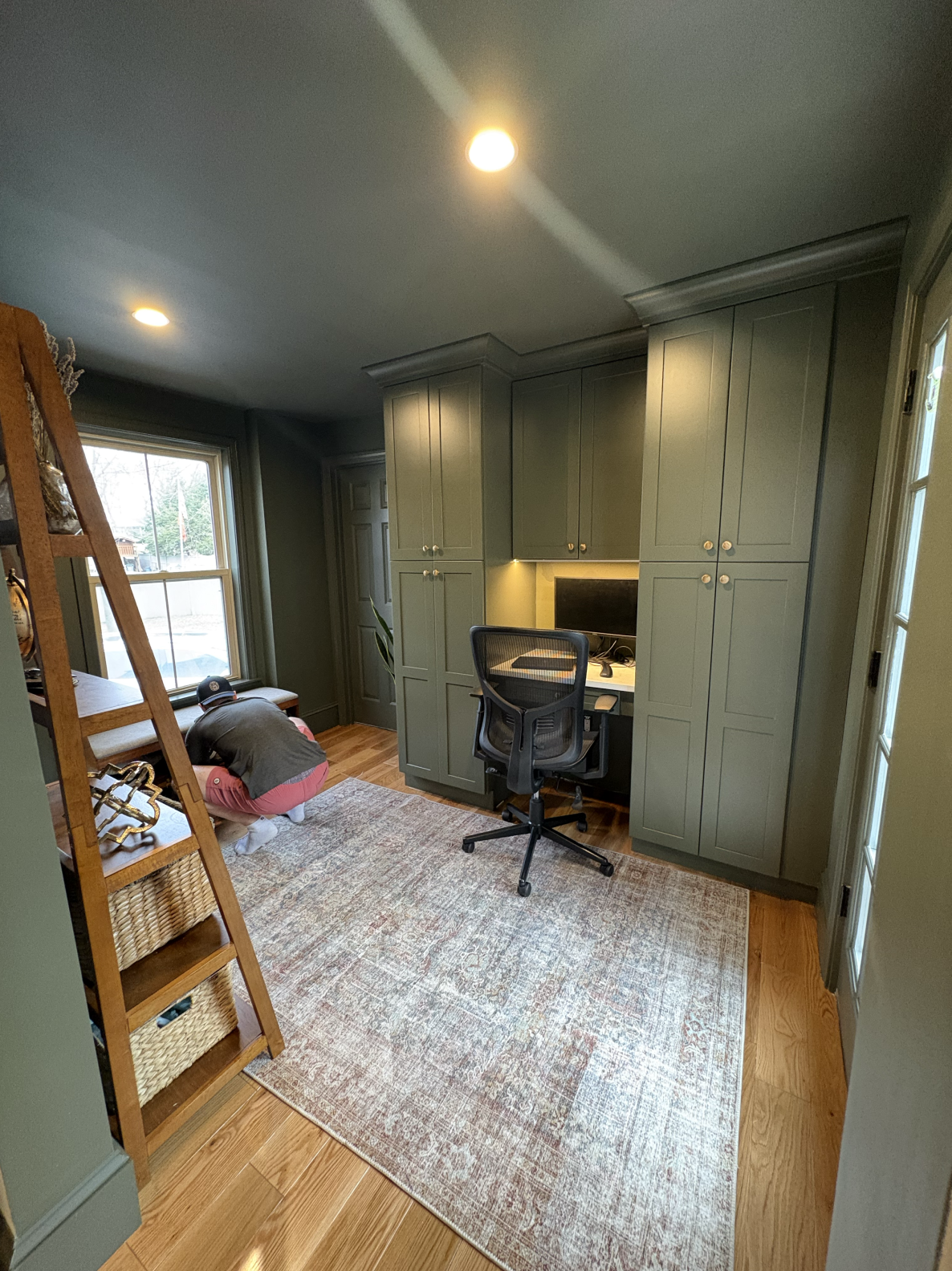 Cozy home office with built-in cabinets and loft bed.